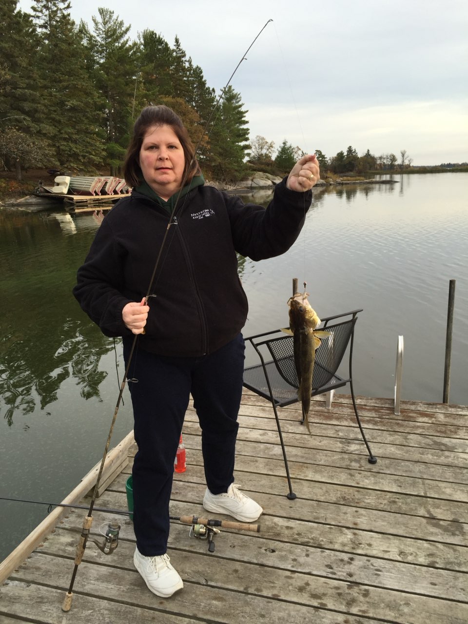 Pam with a fish she cause on a dock
